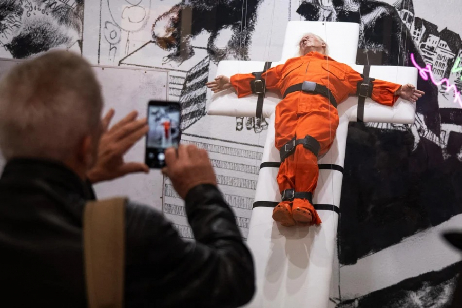 Trump, în costum de pușcăriaș și legat de cruce