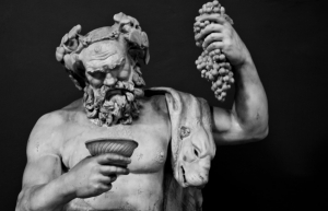 Zeul Bacchus şi simbolul său/ Vinul, licoarea omniprezentă în societatea elenă