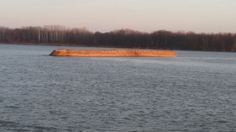 O barjă răsturnată, adusă la vale de apele Dunării