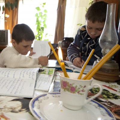 Trei copii fac foamea şi învaţă la lumânare 