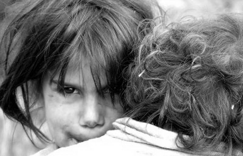 Doi copii înfometaţi, sub cerul liber