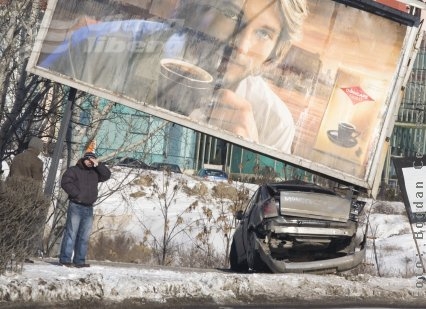 Opel încolăcit în jurul unui panou publicitar